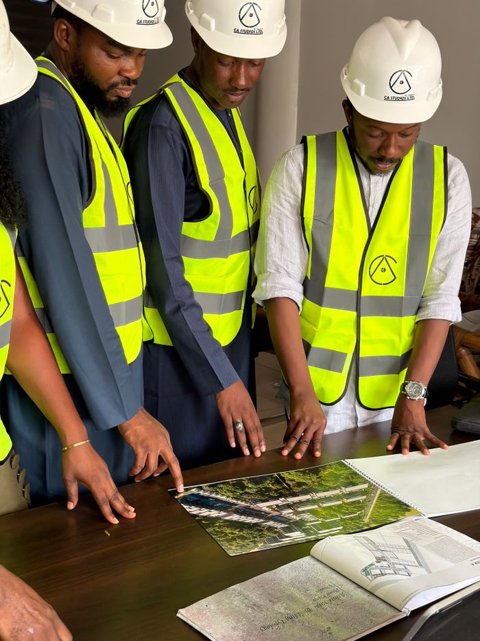 Services Group of engineers and architects examine building plans with safety gear.