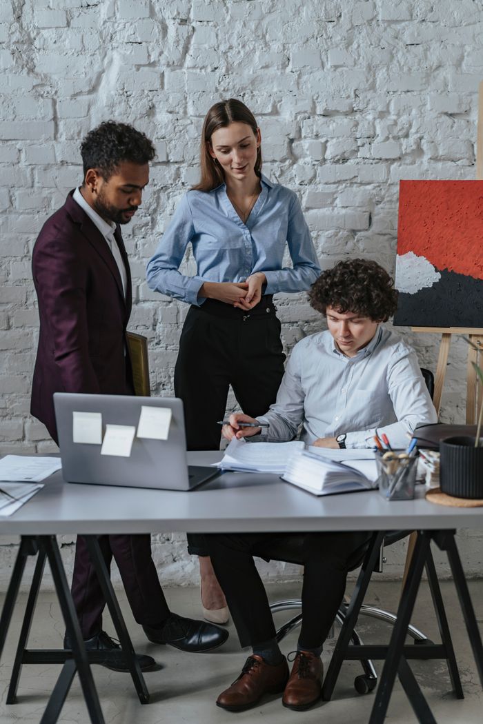 Services A diverse business team collaborates in a modern office setting, discussing documents and ideas.